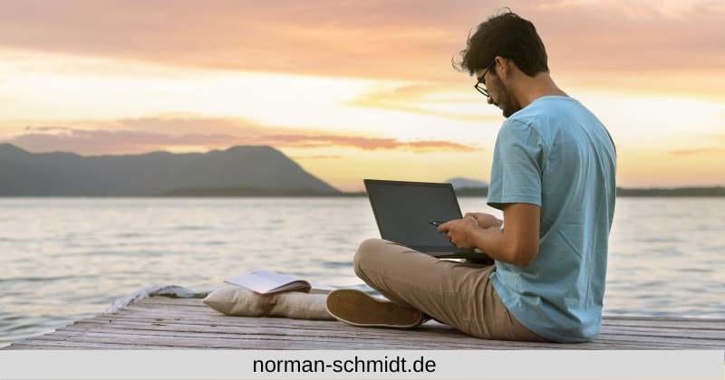 Digitaler Nomade sitzt am Strand mit Notebook und erledigt seine Affiliate Marketing Aufgaben